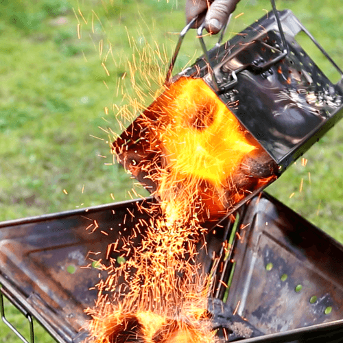 Folding Charcoal Starter pouring out charcoal